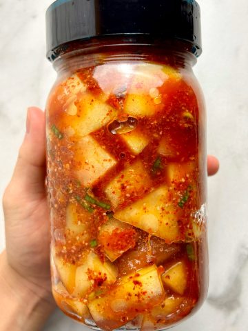 hand holding jar of kimchi