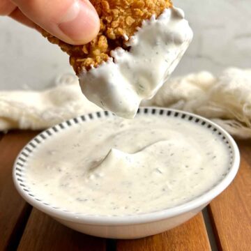 chicken tender being dipped into ranch sauce