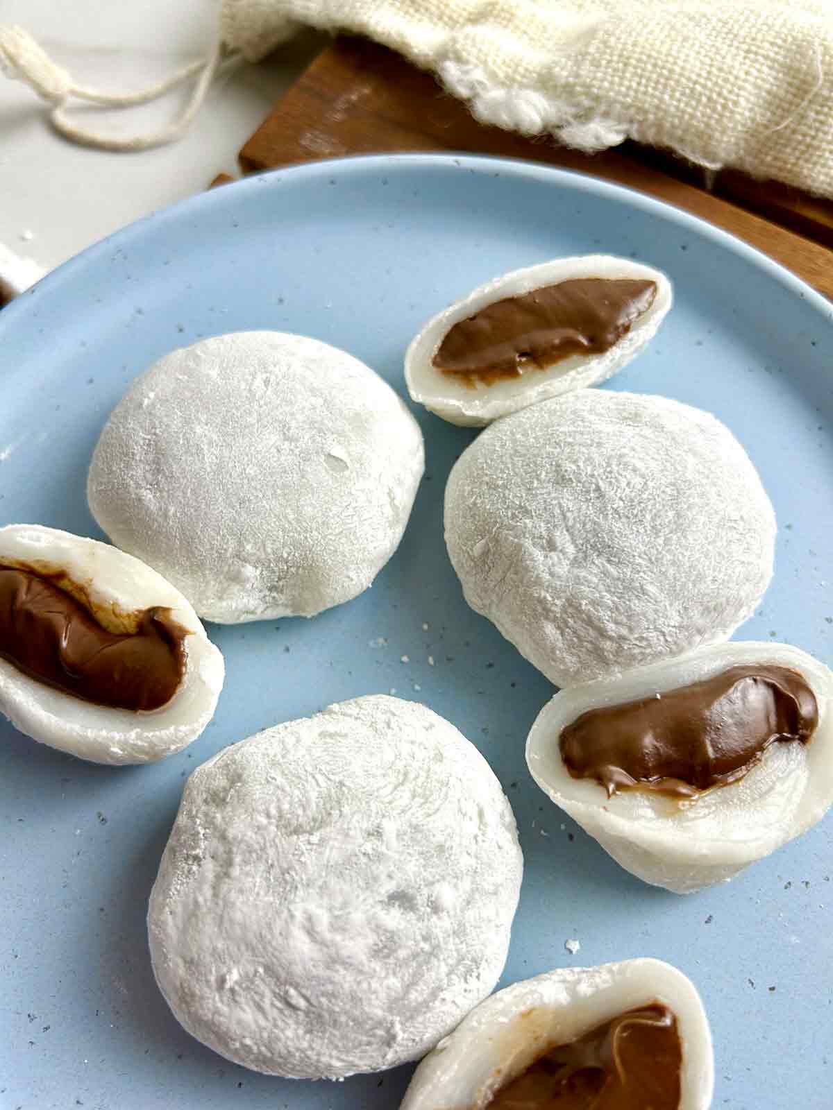 side view of Nutella mochis; some of them are split open to show the chocolate filling.