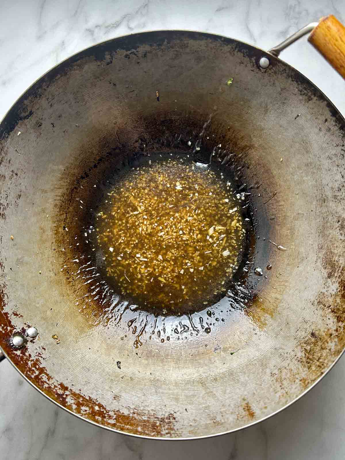 sauce mixture being thickened in wok.