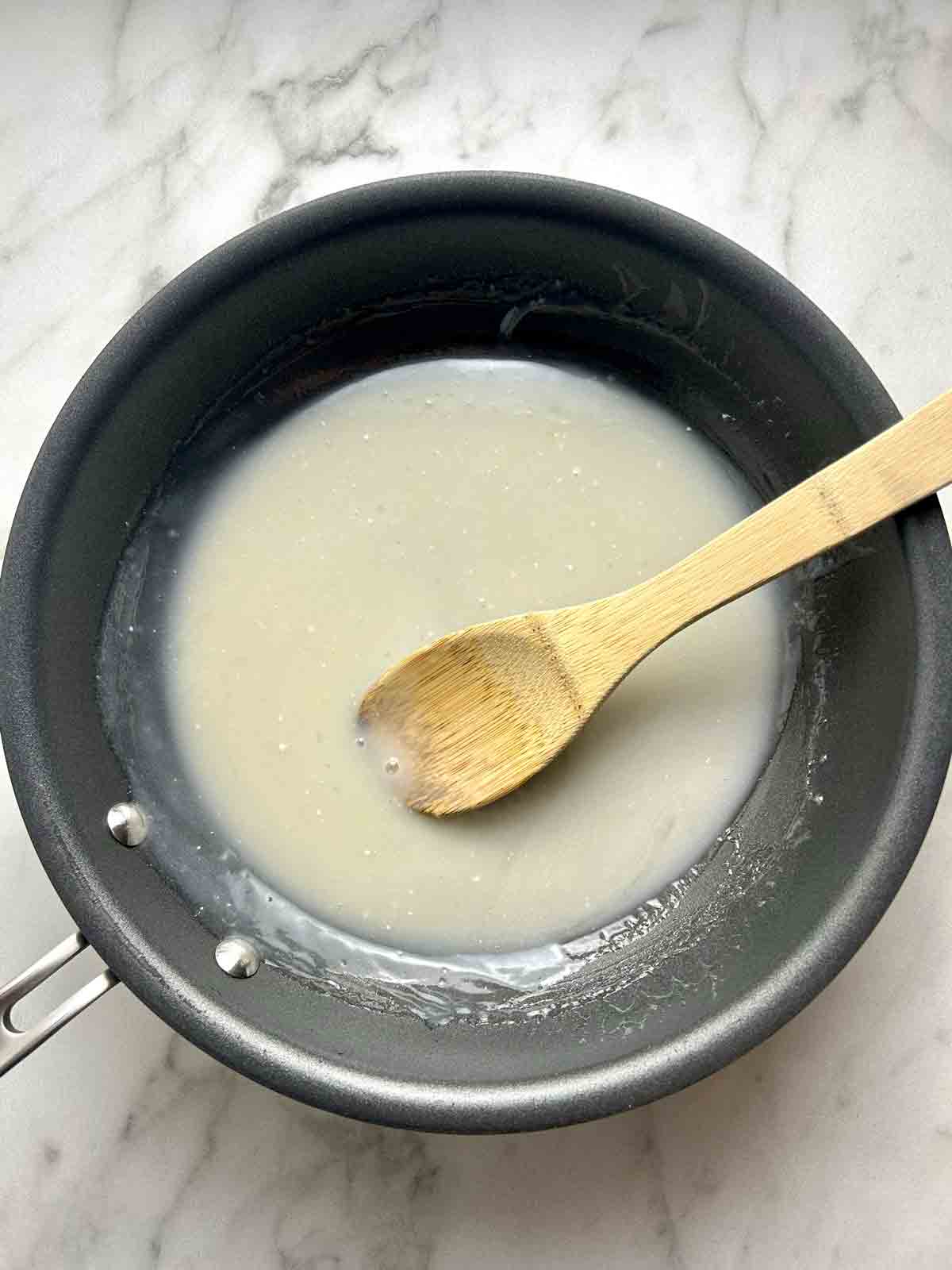 coconut sauce being cooked in pan.