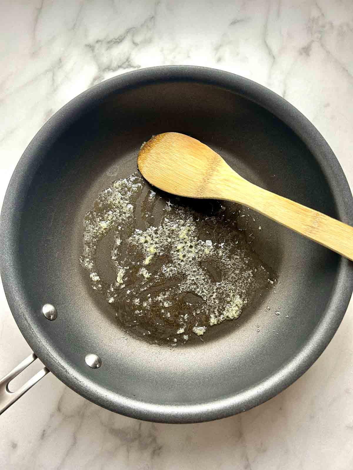 minced ginger being sautéed in oil.