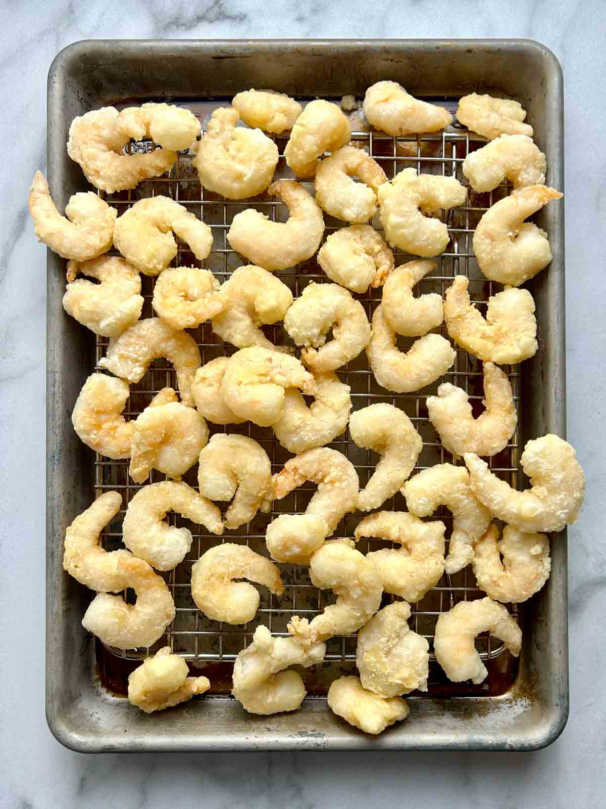 fried shrimp draining on a wire rack.