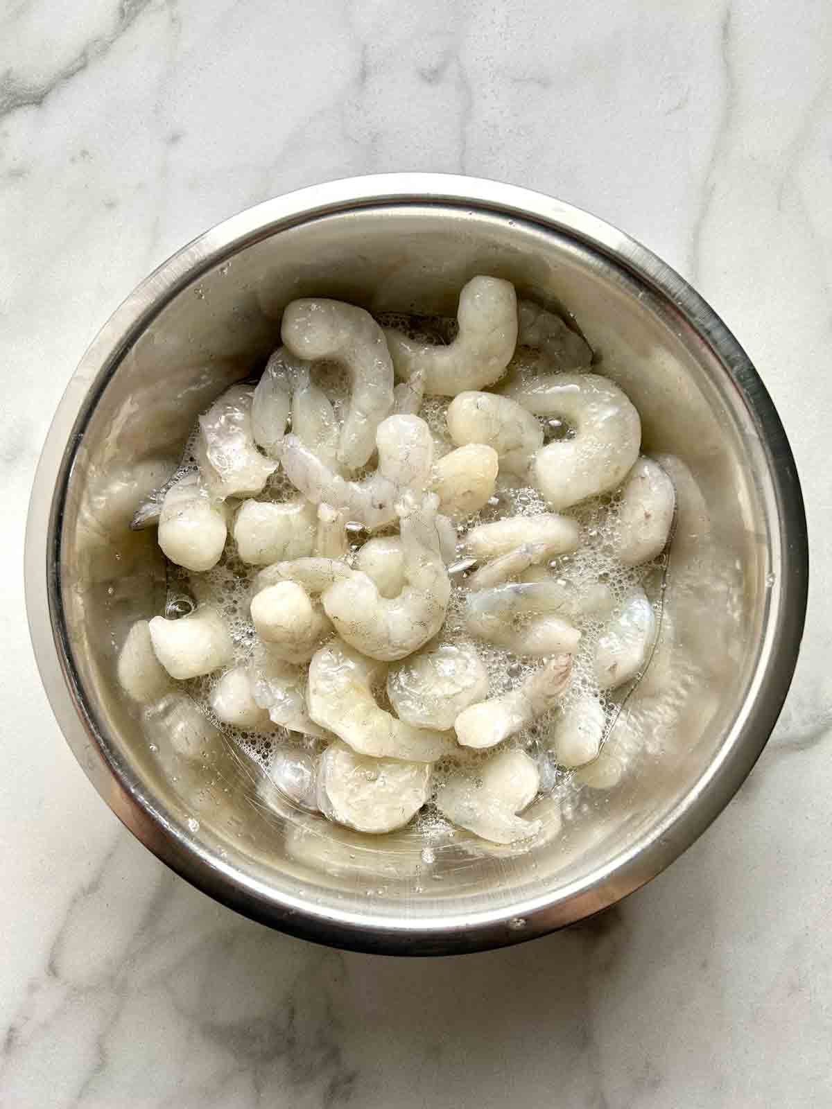 shrimp being marinated in bowl.