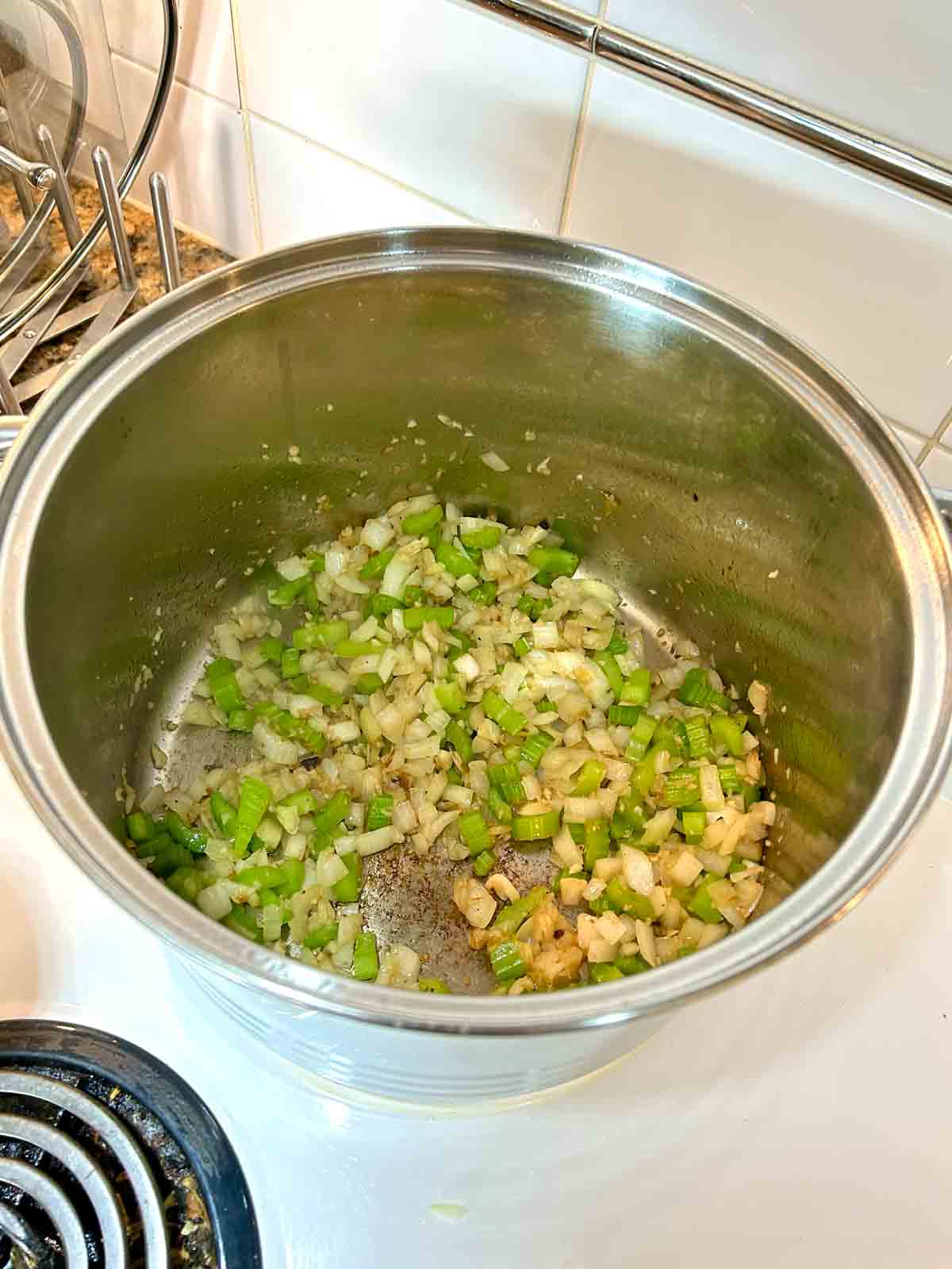onions, celery, and garlic being sautรฉed in pot.