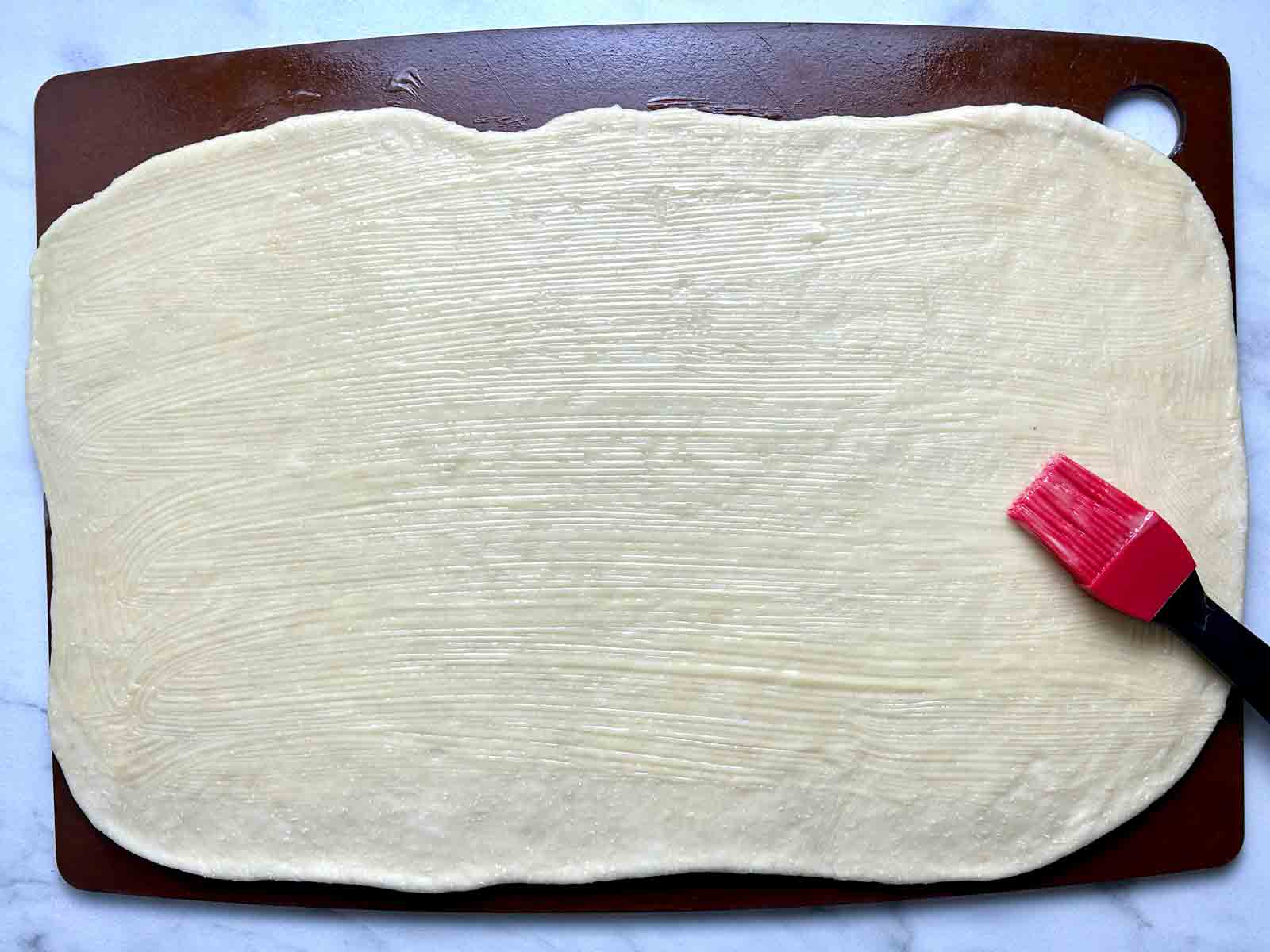 butter being spread on dough.