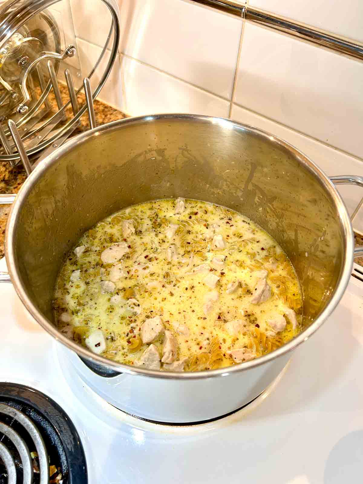 pasta, chicken broth, and cream added to the pot.
