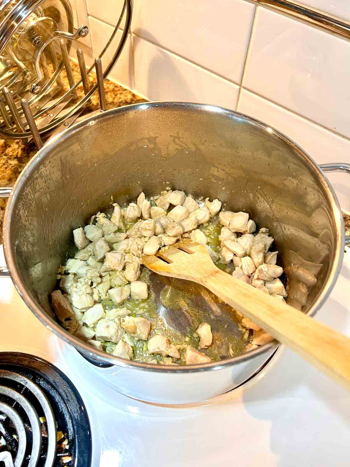 chicken breasts being sautรฉed in pot.