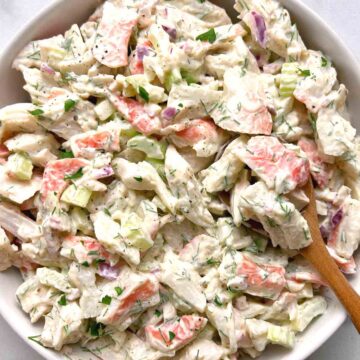 crab salad in bowl with wooden spoon.