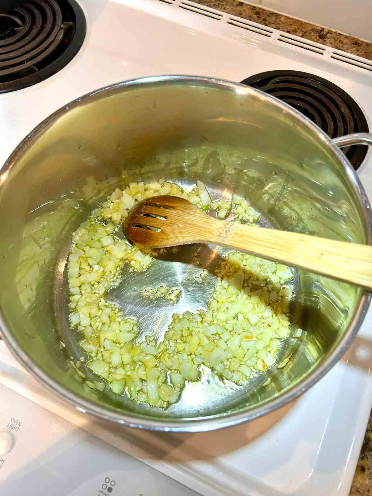 onions and garlic being sautรฉed in pot.