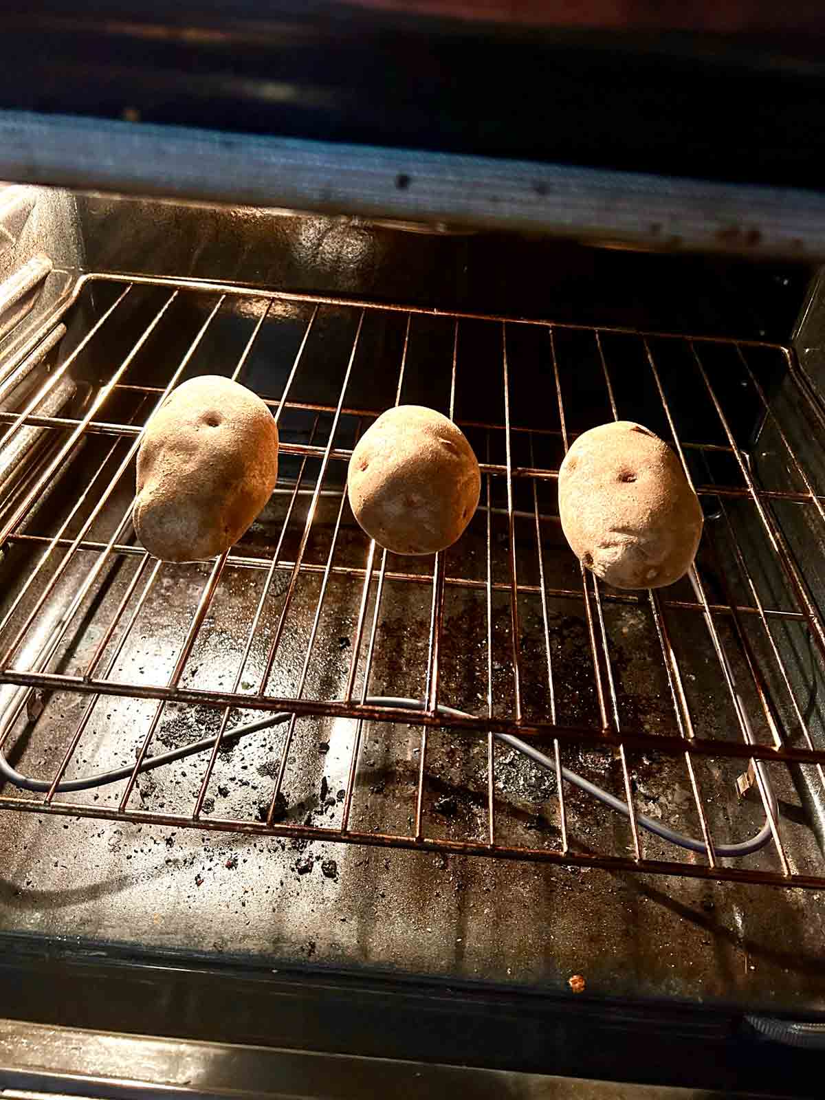 whole potatoes baking directly on oven rack.