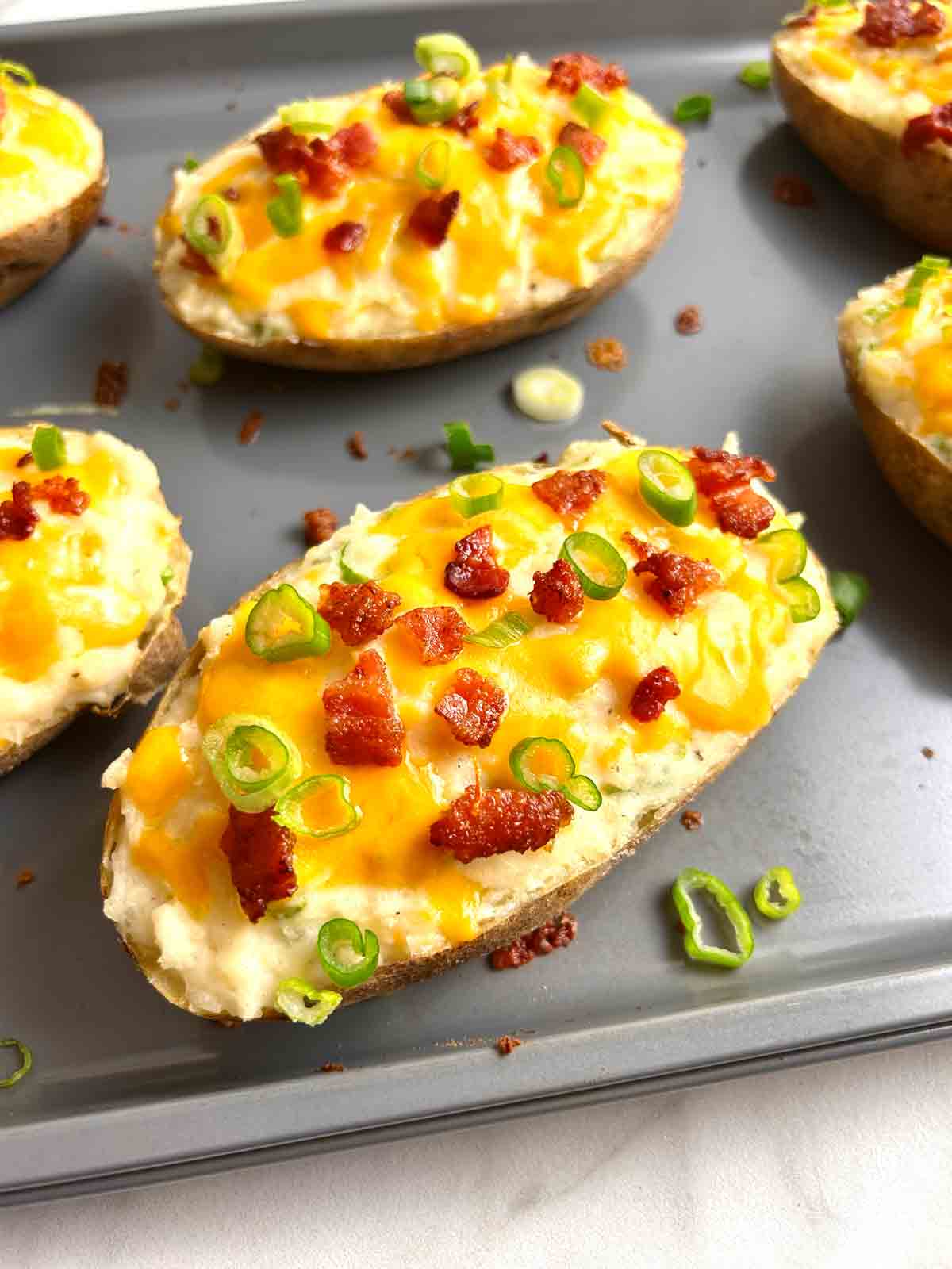 close up of twice baked potato on baking sheet.