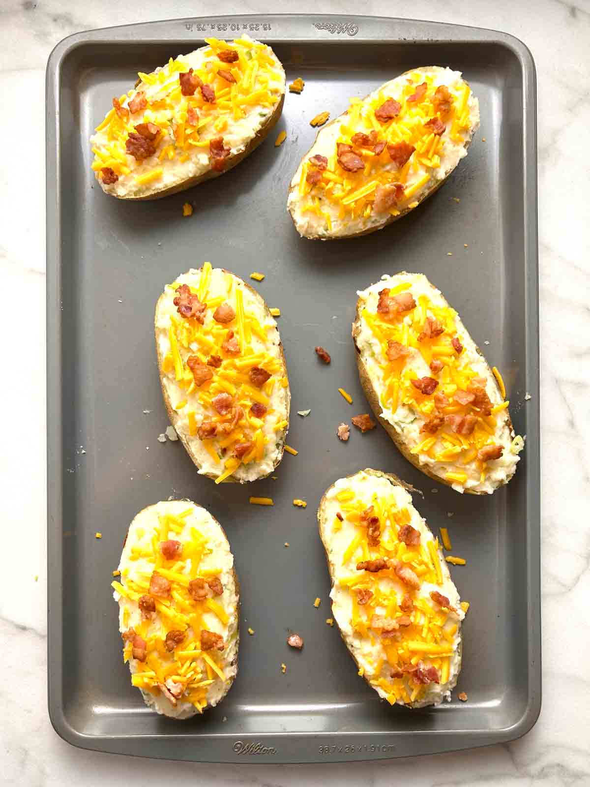 cheddar cheese and bacon sprinkled on potatoes.