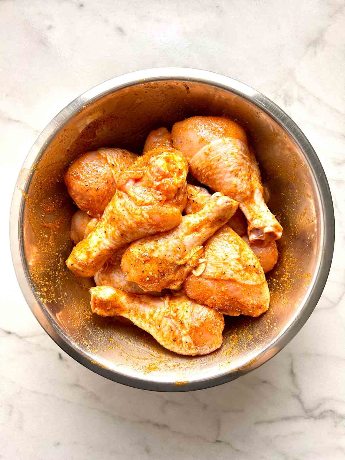 chicken drumsticks mixed with oil and spices.