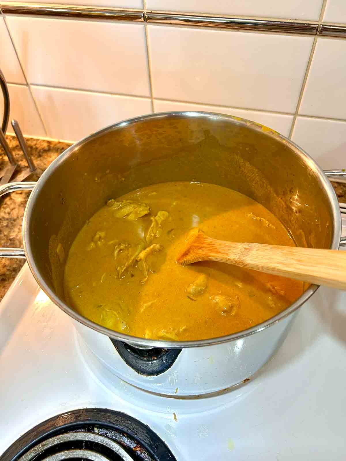 chicken stock, coconut milk, and chicken added to pot.