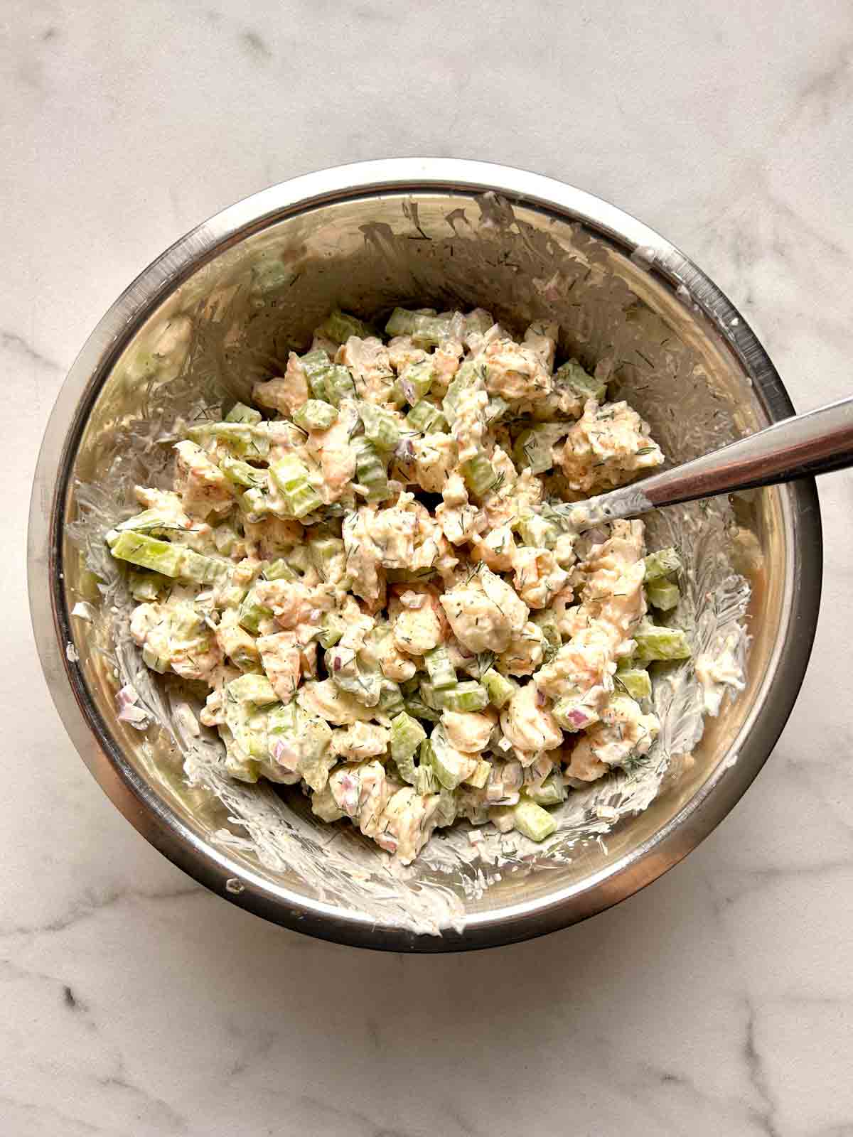 shrimp salad being mixed in bowl.