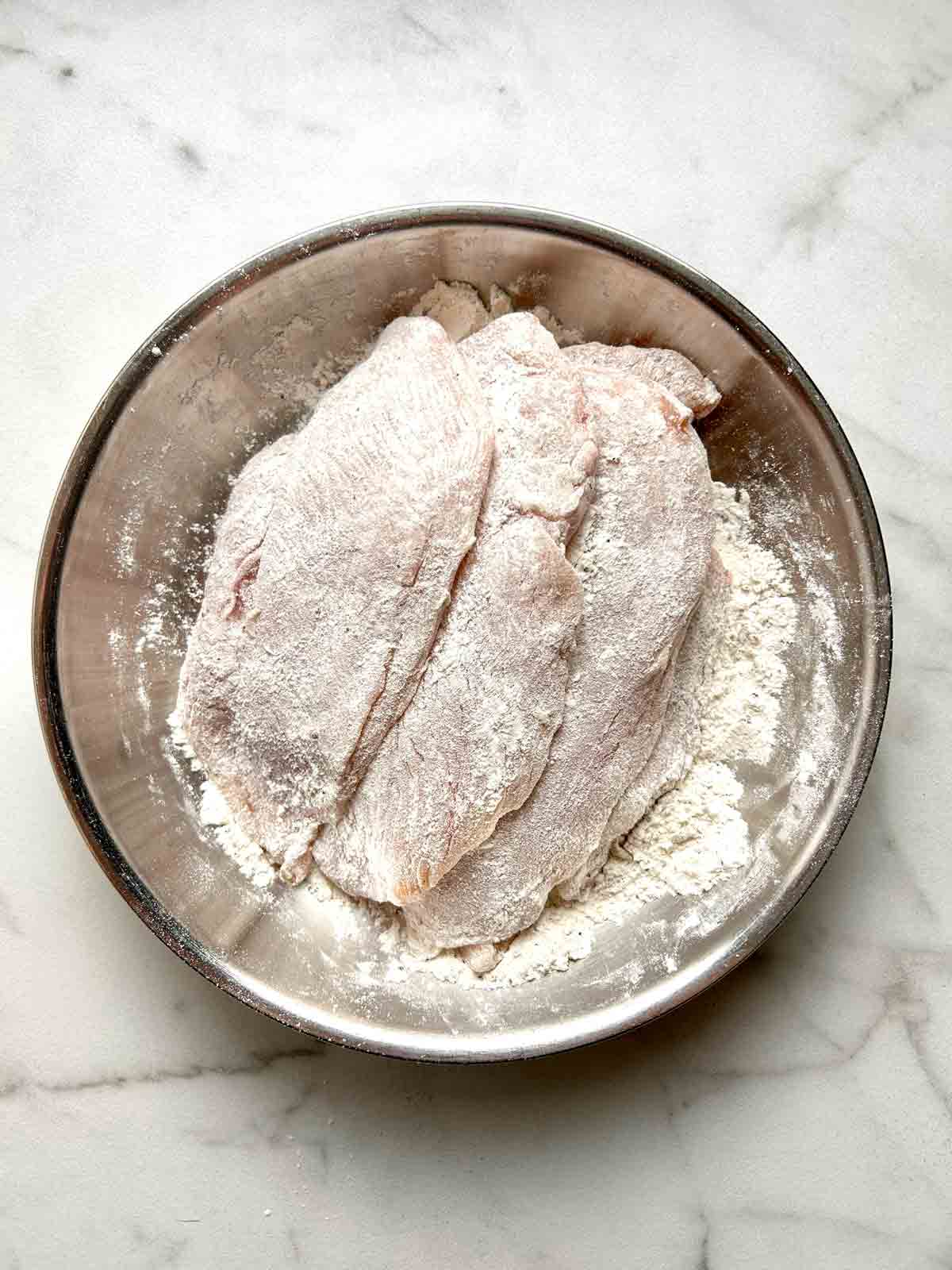coating chicken breasts in flour, salt, and pepper.
