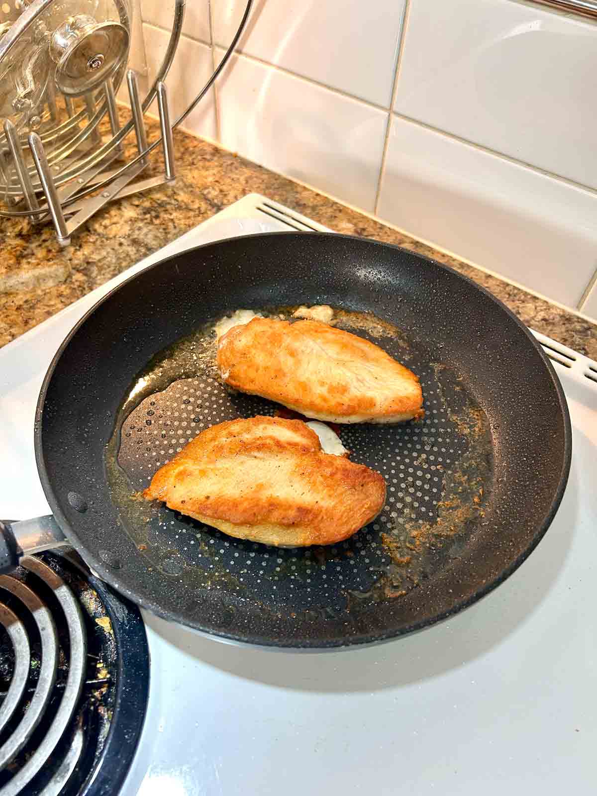 chicken being seared in pan.