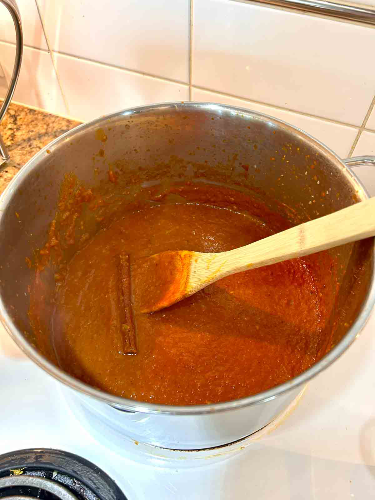 butter chicken sauce simmering with cinnamon stick.