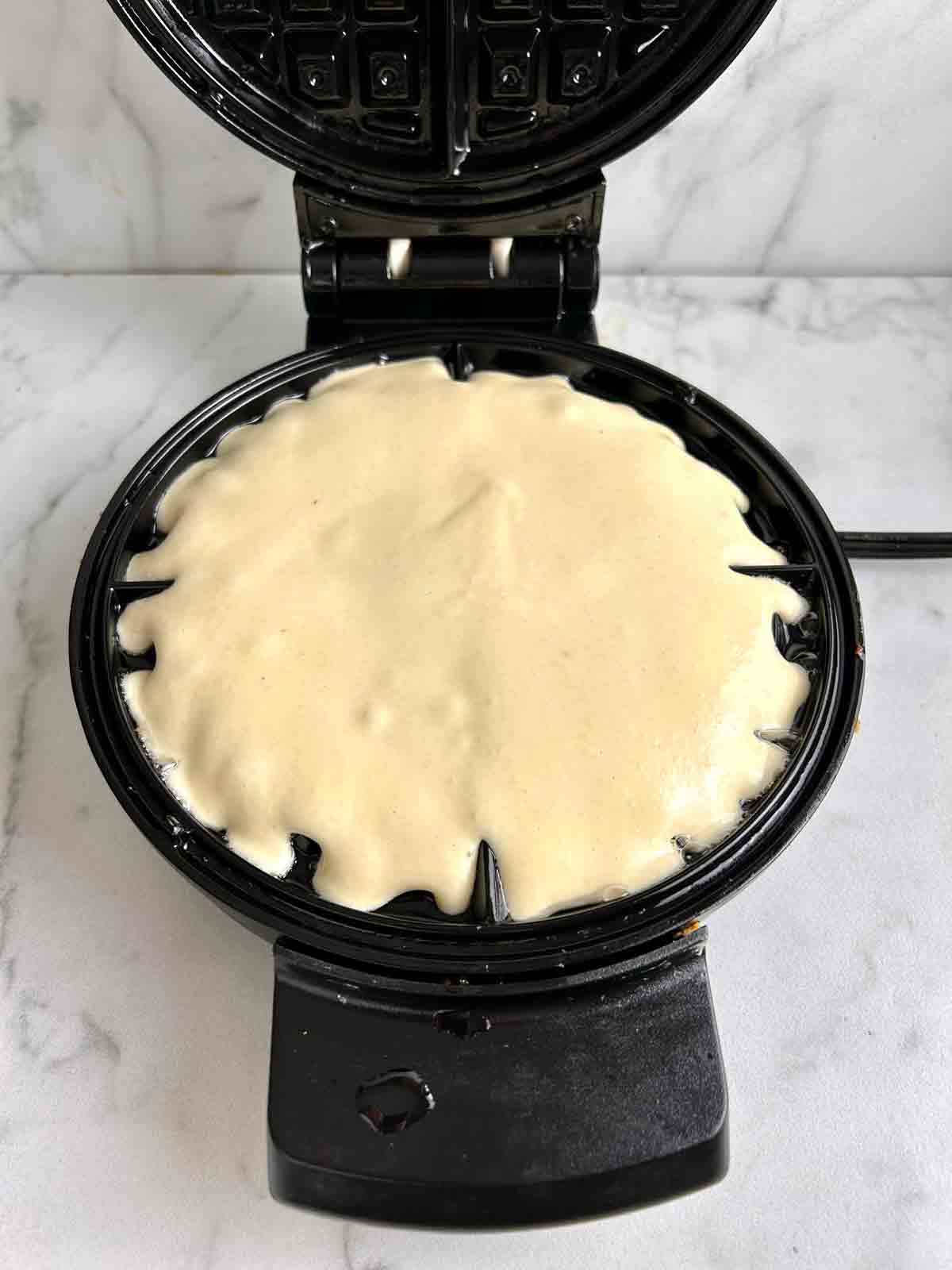 batter scooped into waffle iron.