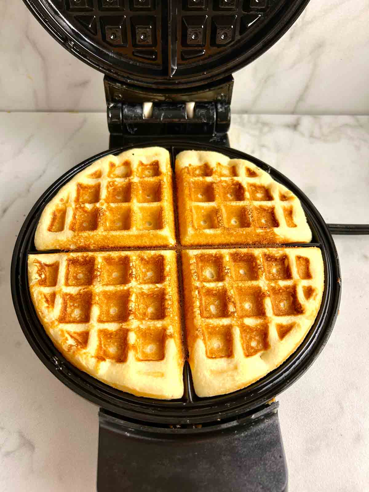 cooked waffle in waffle iron.