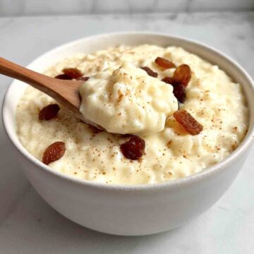 bowl of rice pudding with raisins and cinnamon on top.