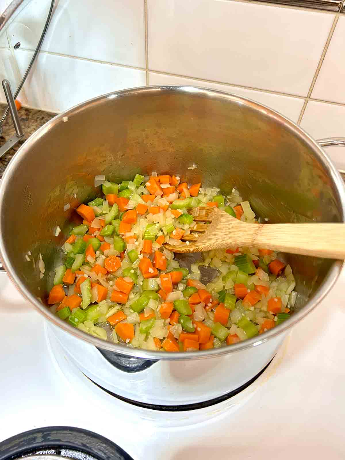 aromatics being cooked in large pot.