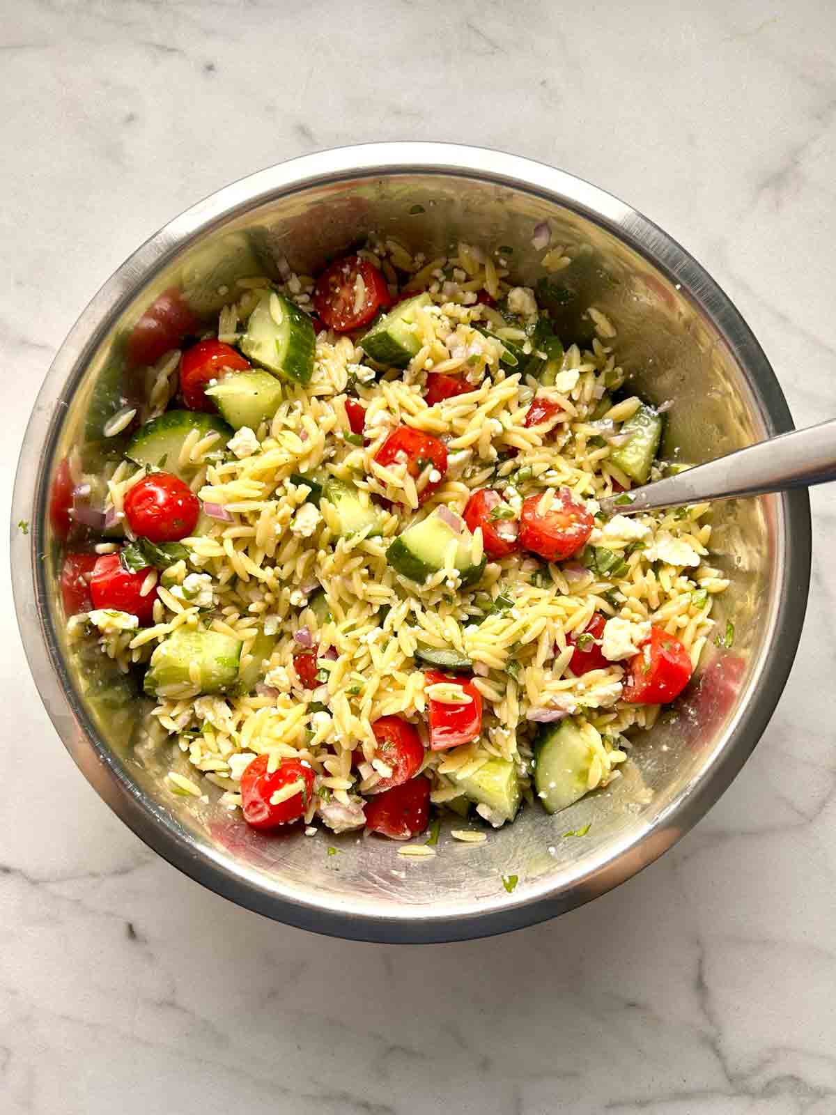 orzo salad mixed in bowl.