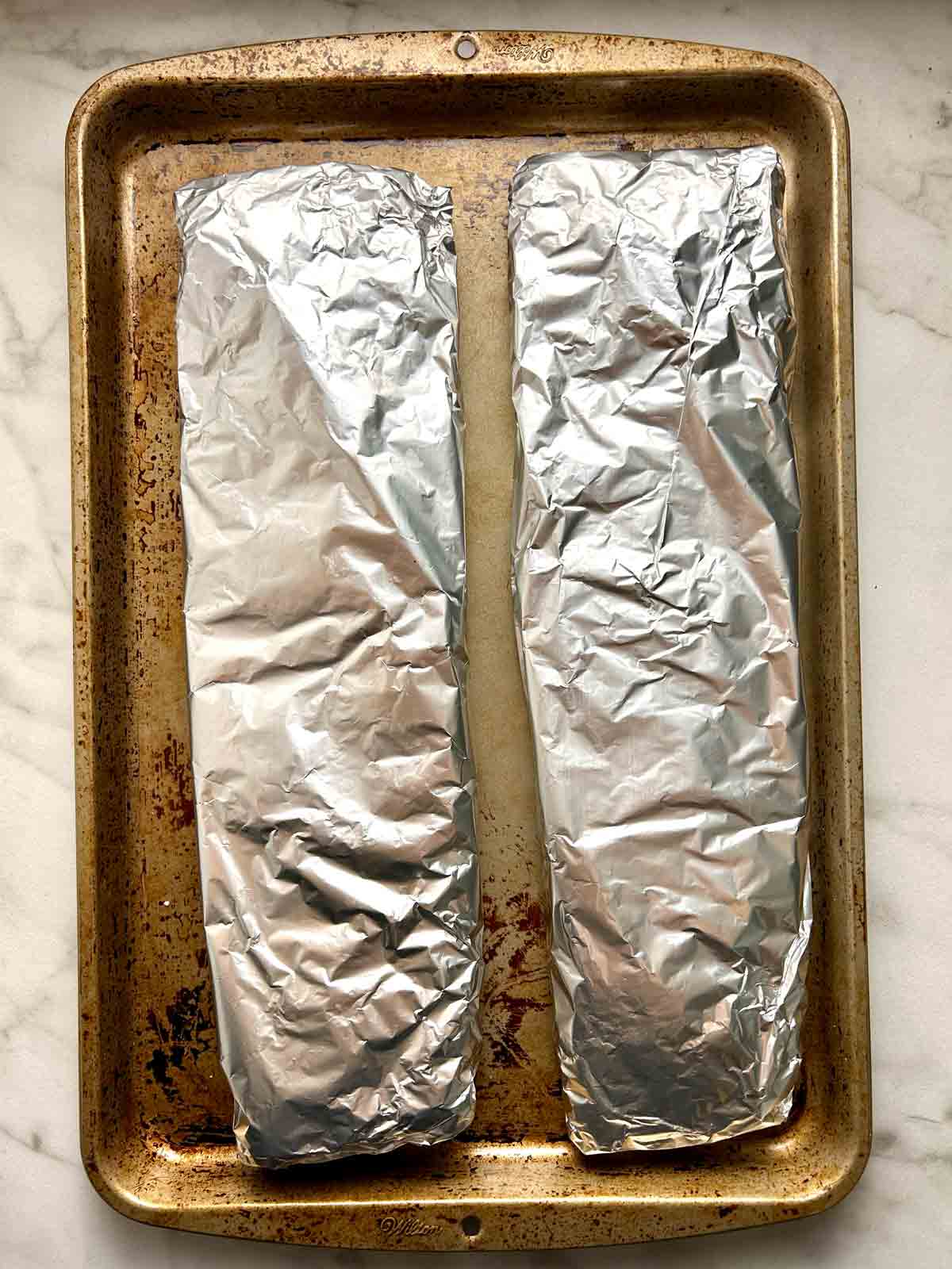ribs double wrapped in foil and placed on baking sheet.