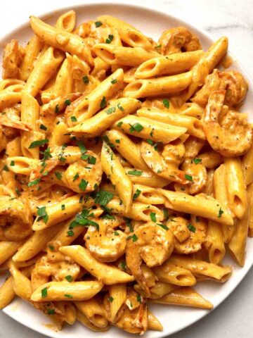 plate of cajun shrimp pasta with parsley sprinkled on top.