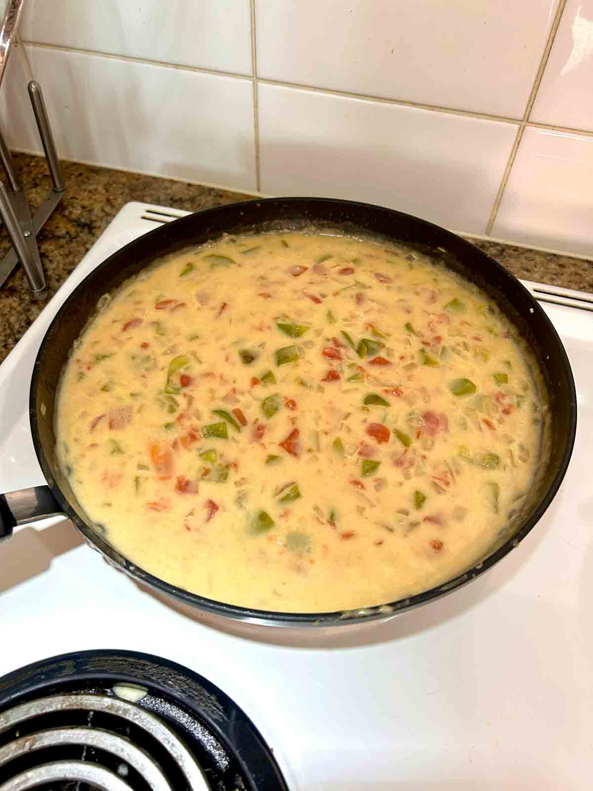 broth, diced tomatoes, and cream of chicken added to pan.