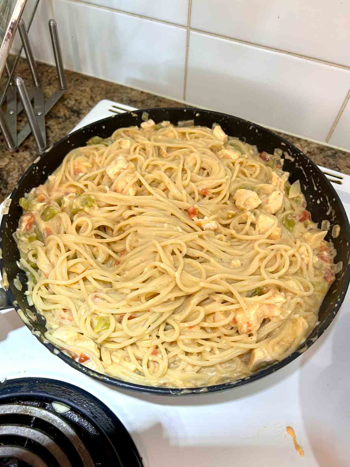 spaghetti tossed with sauce in pan.