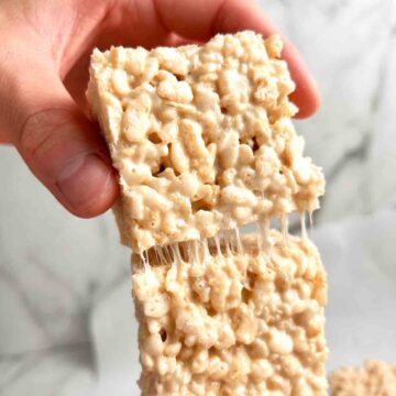 hand pulling Rice Krispies square from another square.