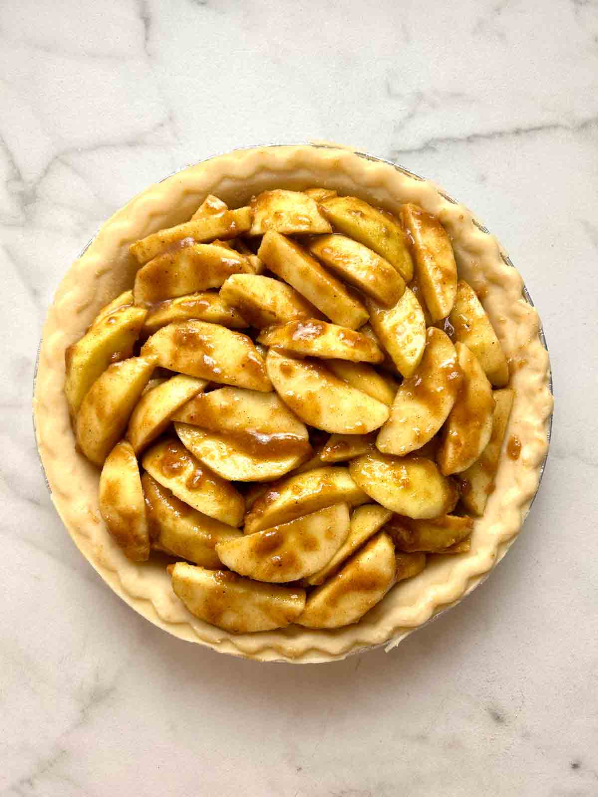 apple filling spread into pie crust.