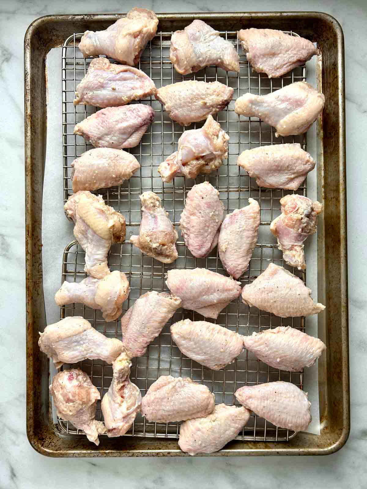 wings arranged on baking rack on baking sheet.