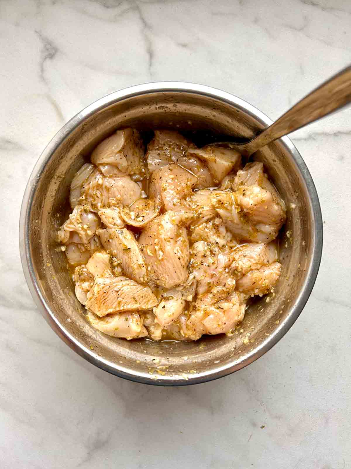 chicken being marinated in bowl.