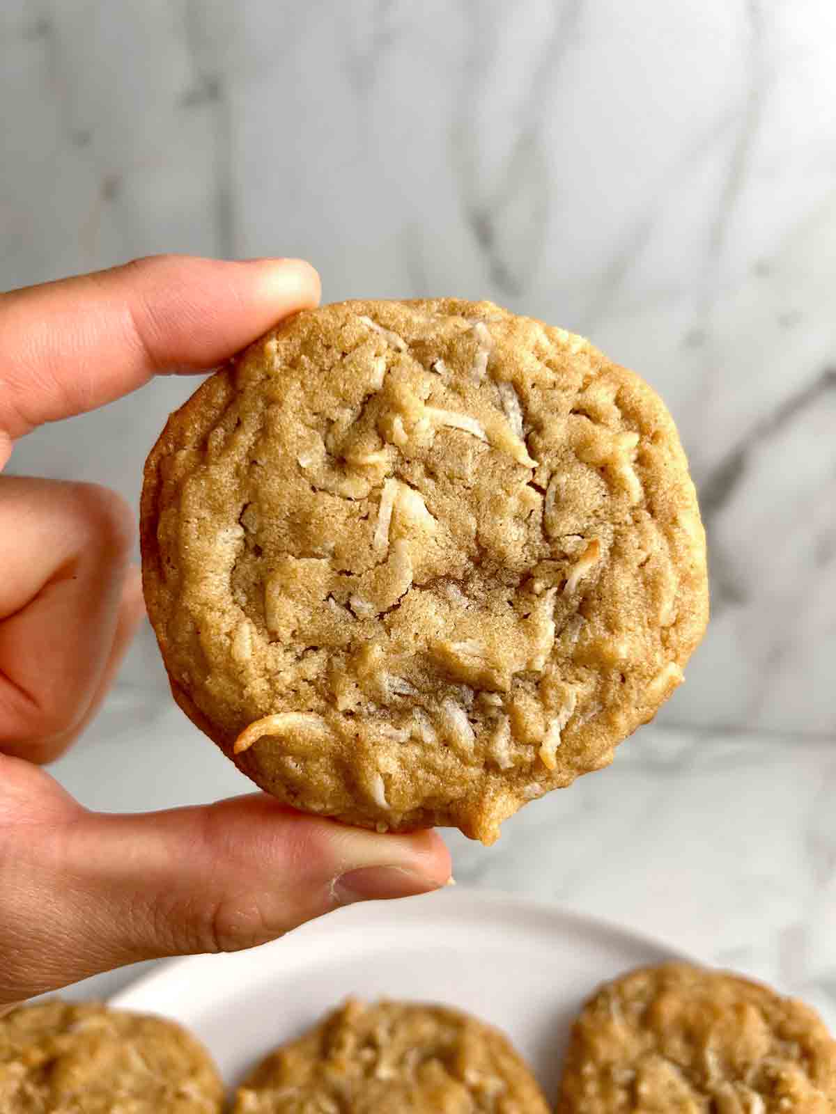 hand holding coconut cookie.