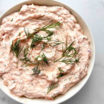 bowl of smoked salmon dip with dill fronds garnished on top.