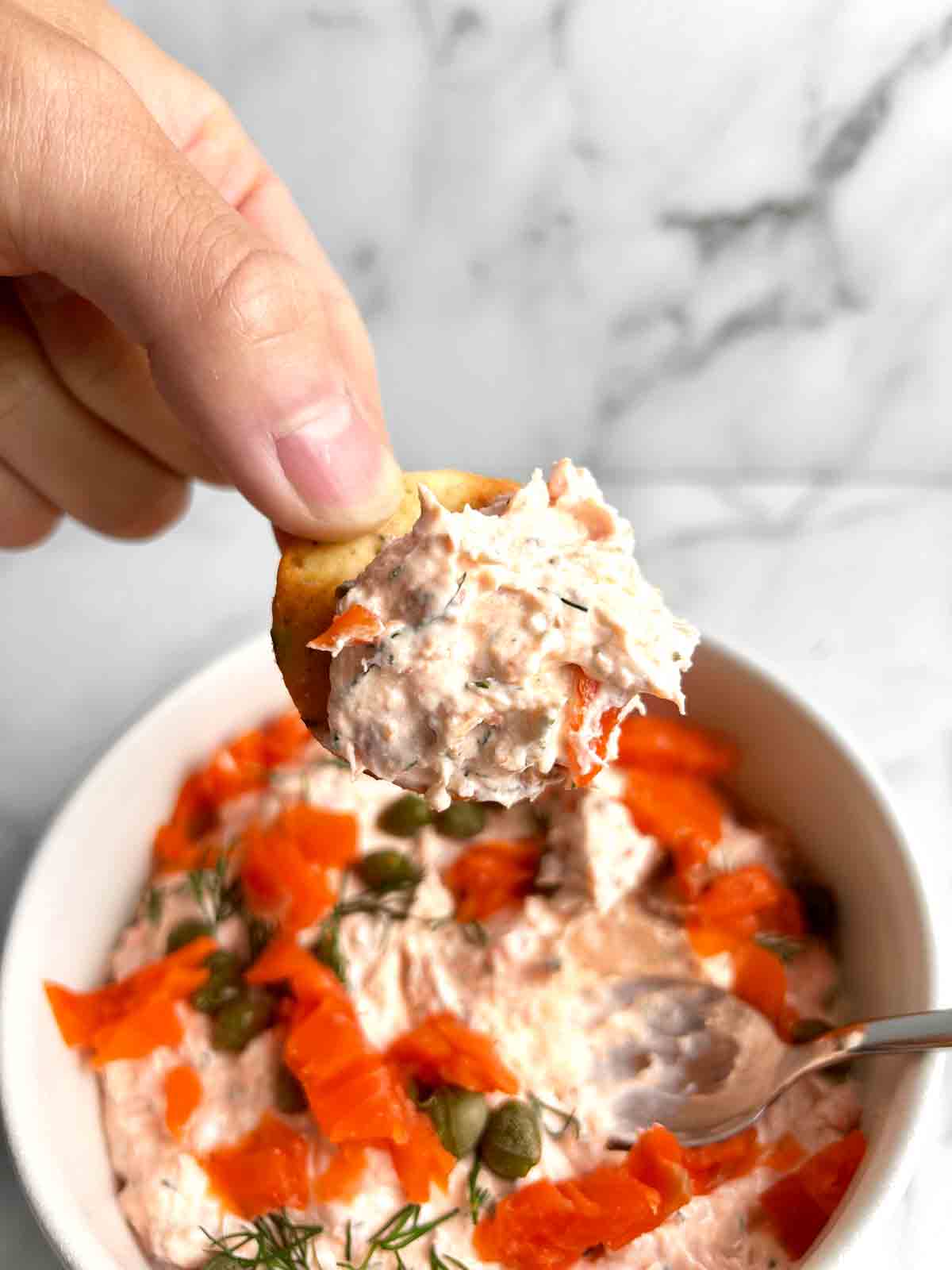 scooping up salmon dip with pita cracker.