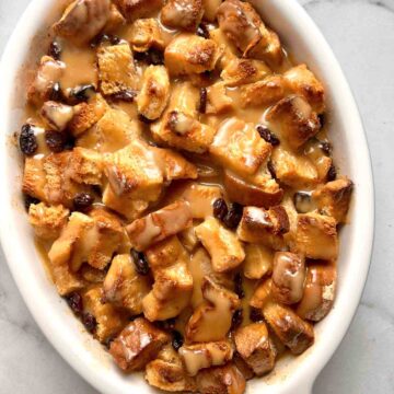 bread pudding with vanilla sauce drizzled over it.