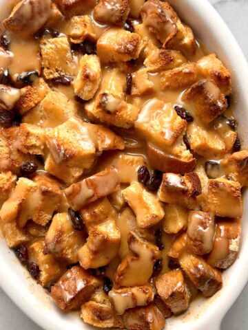 bread pudding with vanilla sauce drizzled over it.
