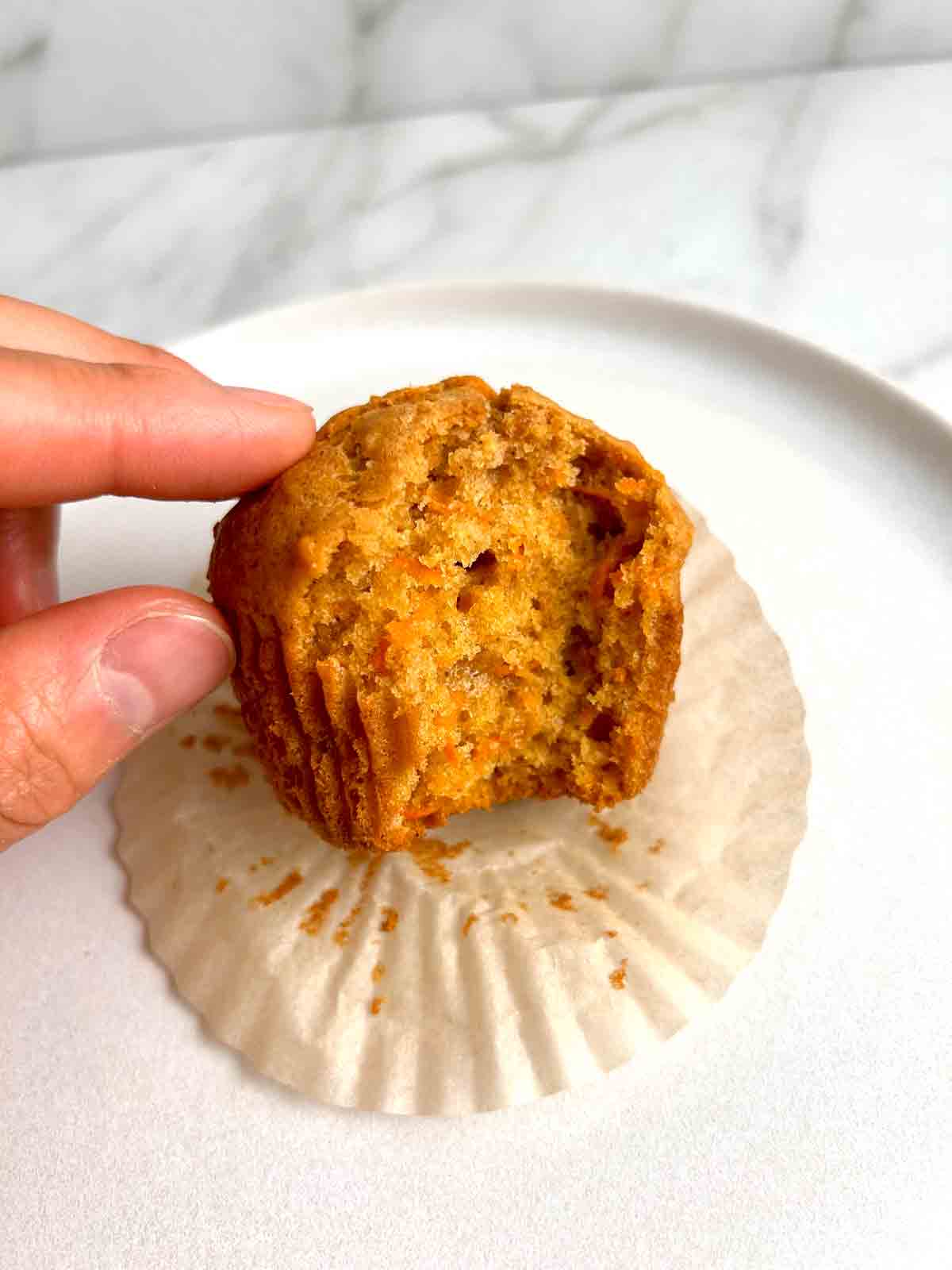 carrot muffin with bite taken out of it.