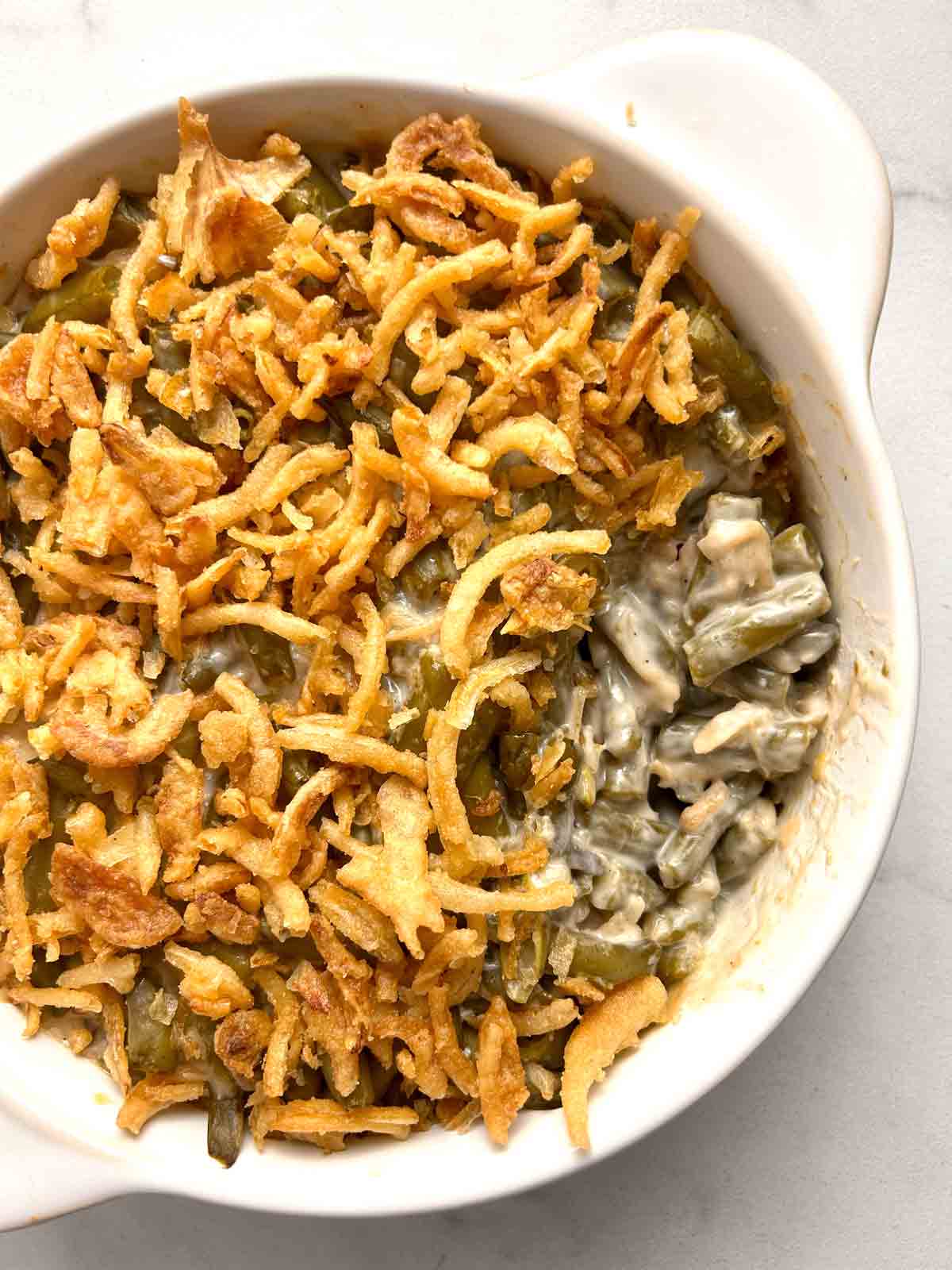 close up of green bean casserole with portion scoped out of it.