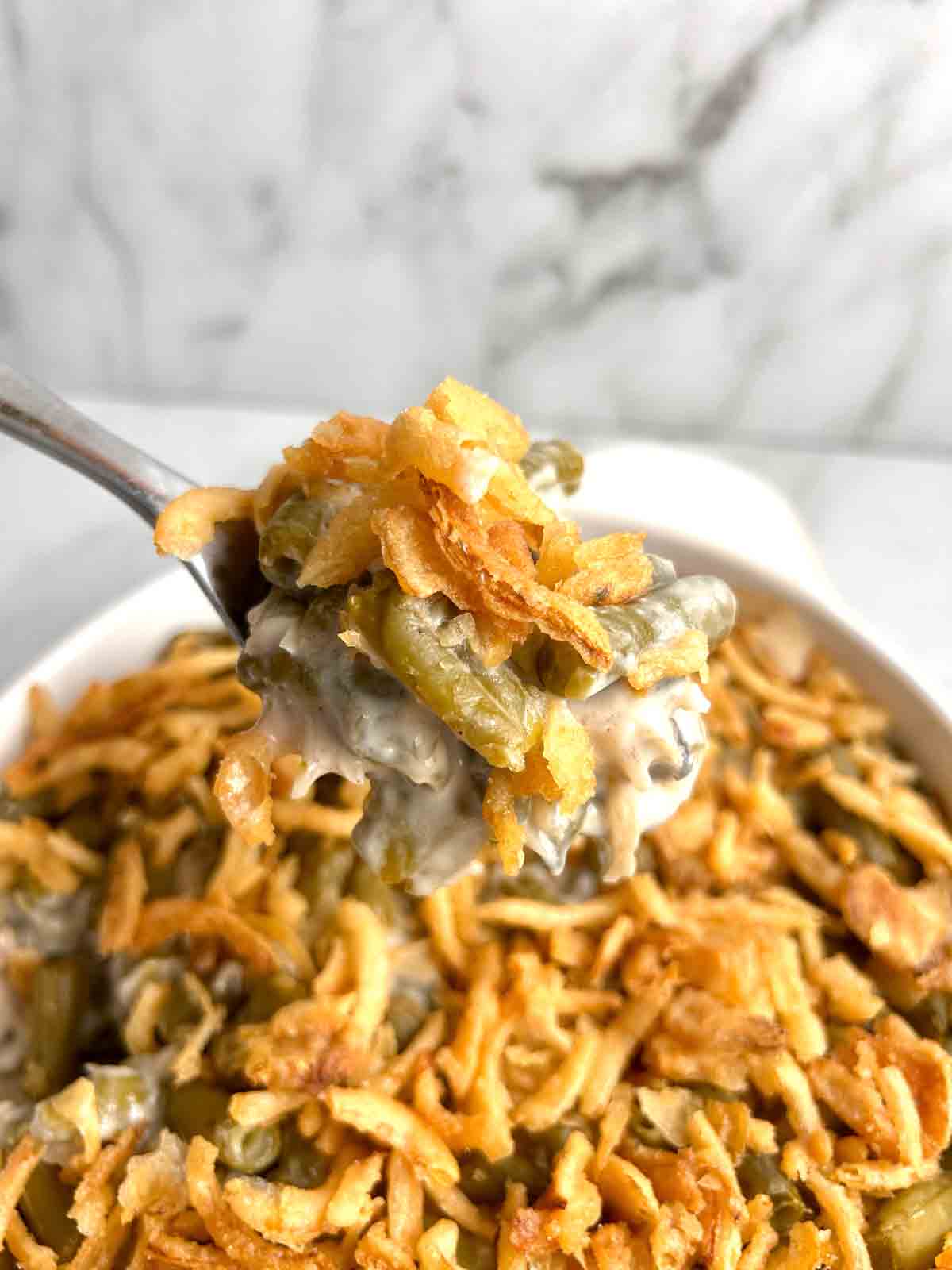 spoon scooping portion of green bean casserole.