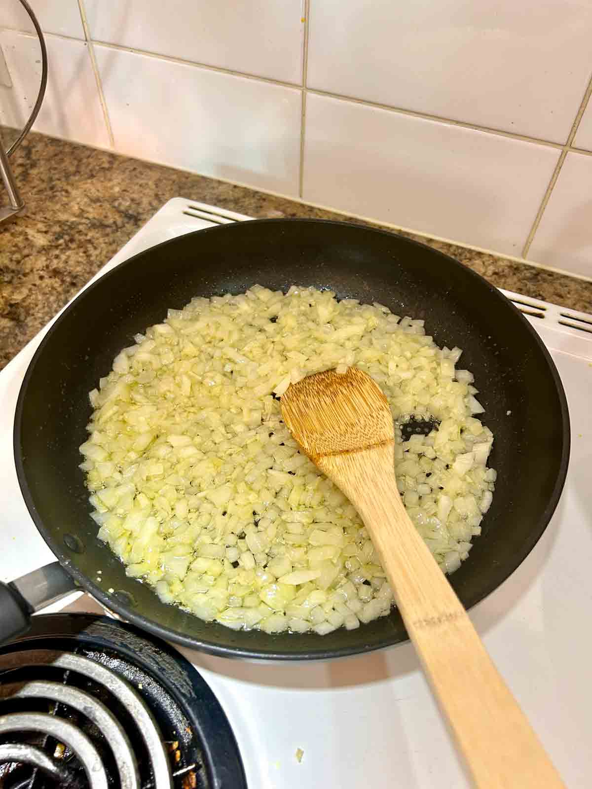 onion and garlic being sautรฉed in pan.