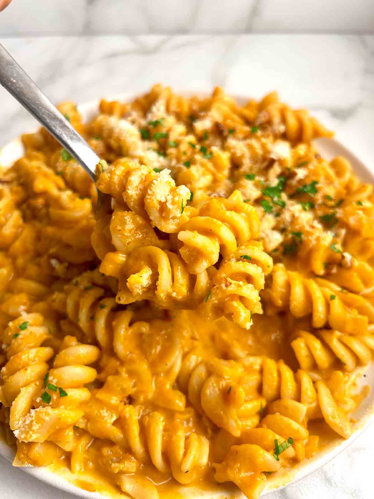 spoon lifting pumpkin pasta from plate.