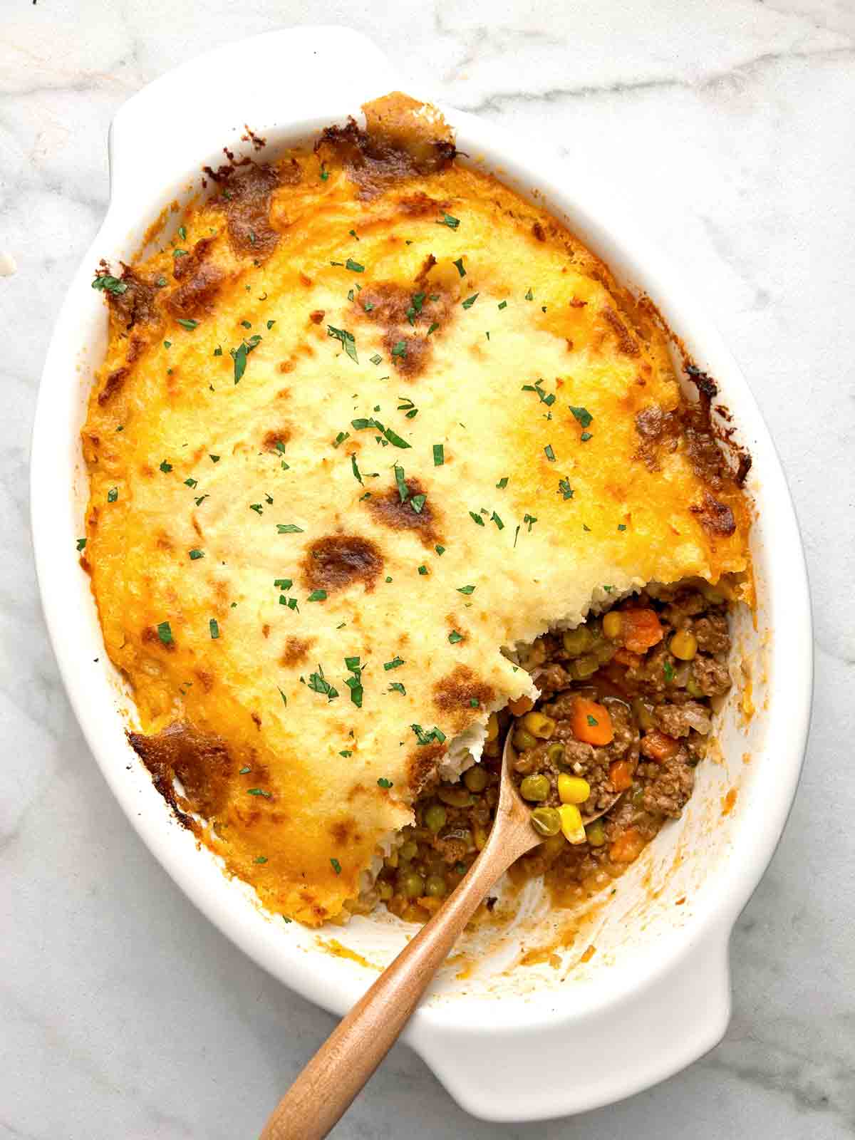 shepherd's pie with chunk taken out of it to show the meat filling.