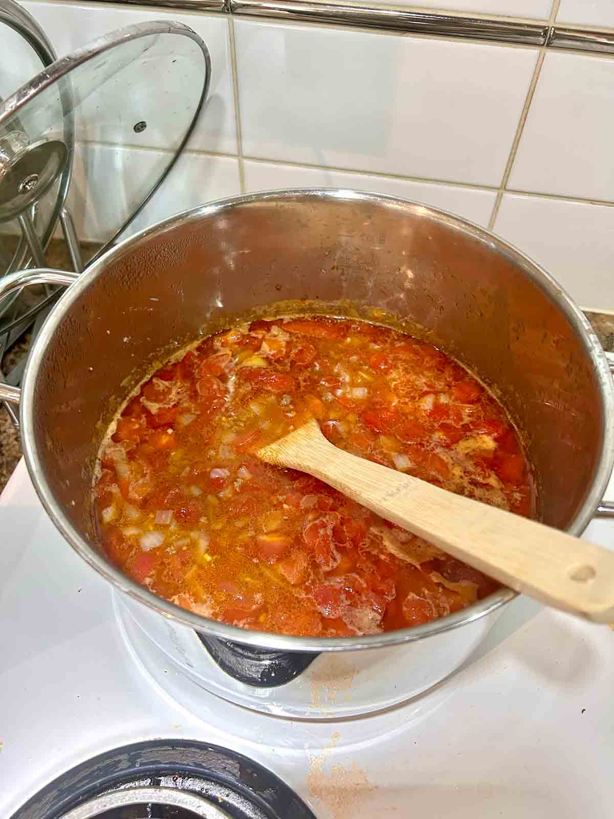 chicken broth and diced tomatoes added and simmered in pot.