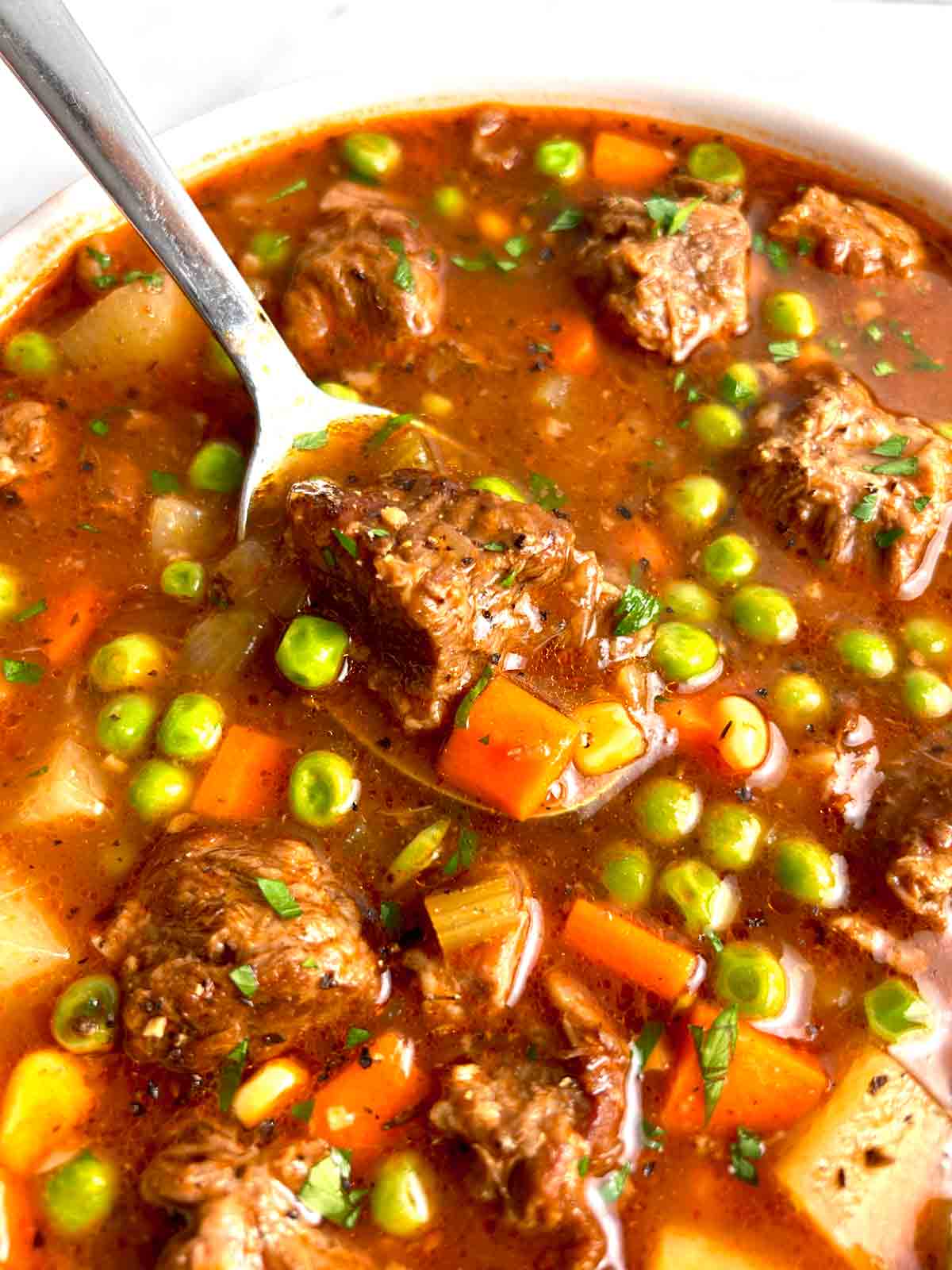 spoon lifting soup out of bowl.