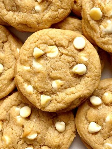 close up of white chocolate chip cookies on plate.